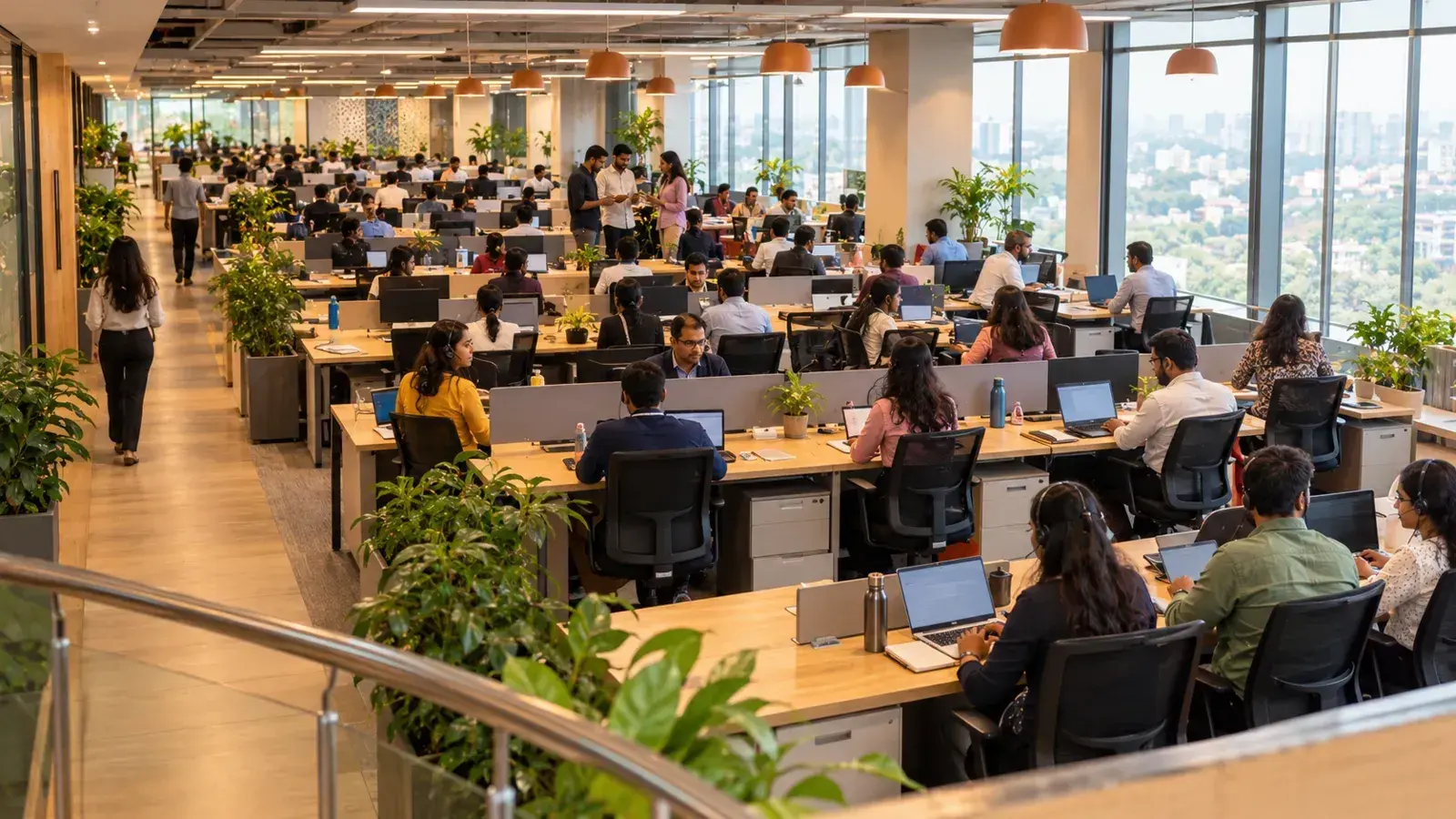 A large sales team works at rows of desks in an open-plan office