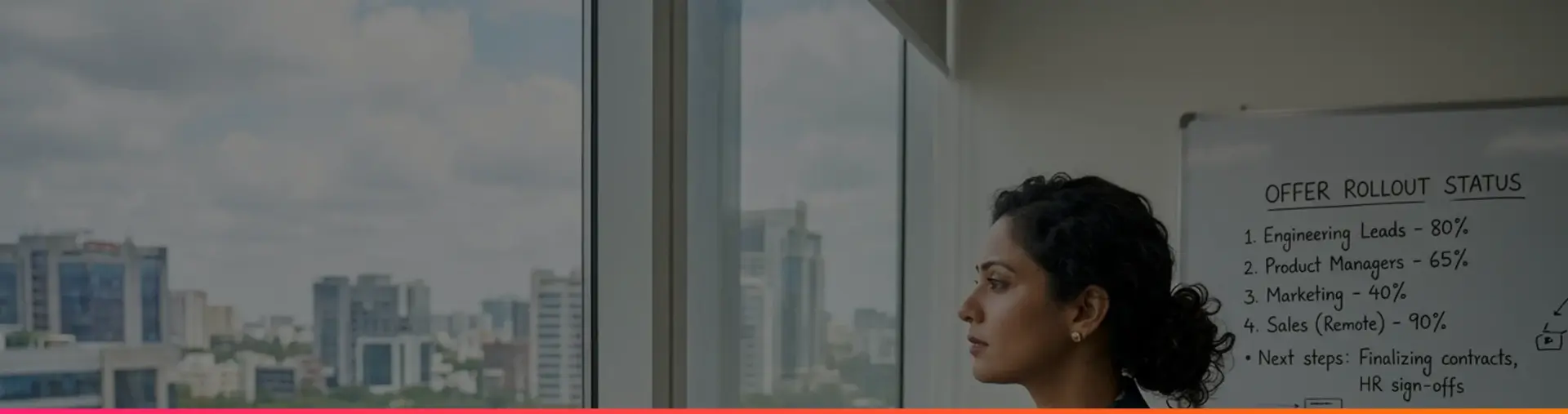A woman in a blazer looking out of an office window over a city, beside a whiteboard tracking offer rollout status