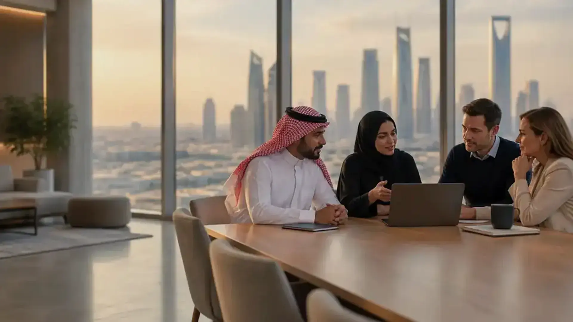 A Total Rewards team in a Riyadh office discussing pay decisions with the KAFD towers behind them.
